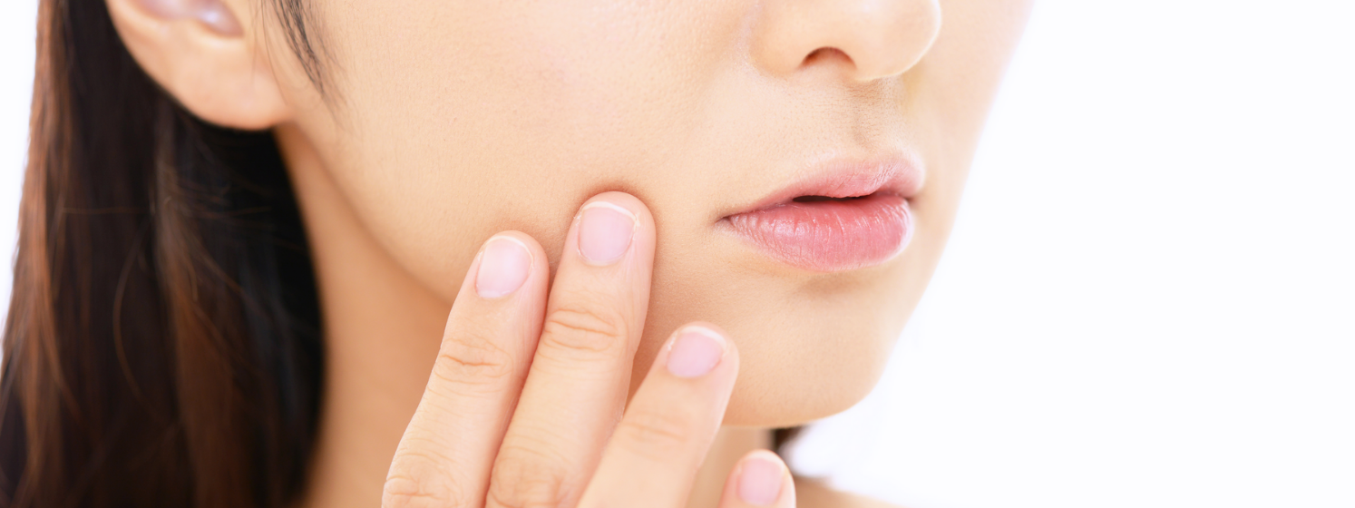 Woman touching her cheek is affected by skin aging.